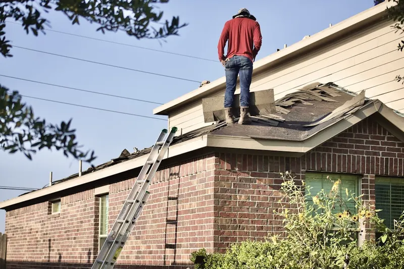 Professional roofer working on a residential roof in Asbury Woods